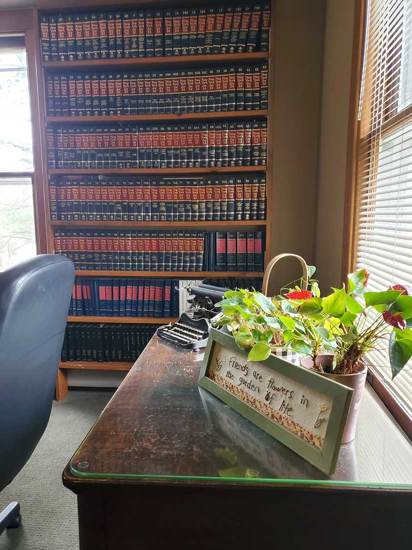 Inside of the office, with law books and a house plant